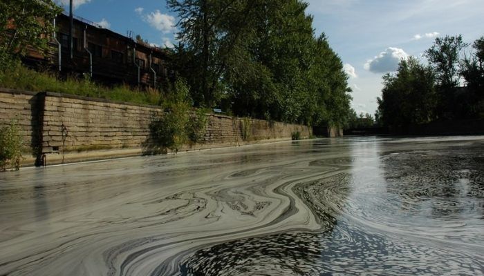 Загрязнение реки промышленными сбросами